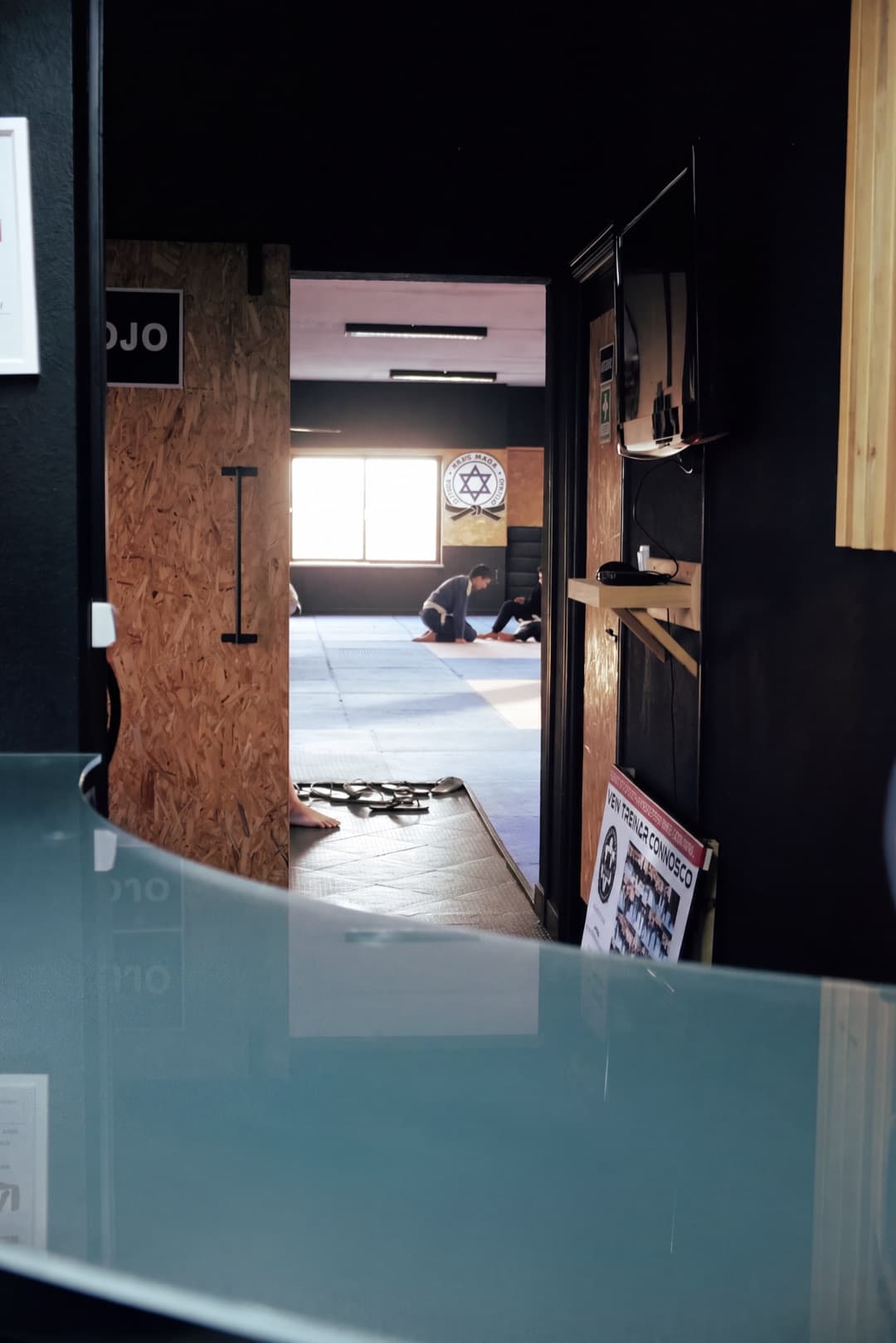 Entrada do dojo da Lusitanos, em Viseu, com vista para um treino de Jiu-Jitsu no tatami